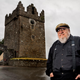 Martin stands outside a castle that is, sadly, not in his backyard.